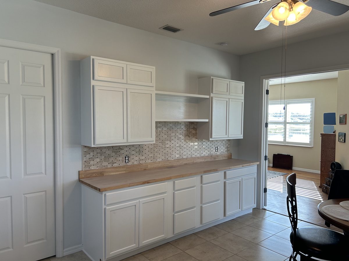 Kitchen after refresh with white cabinets and new tile backsplash